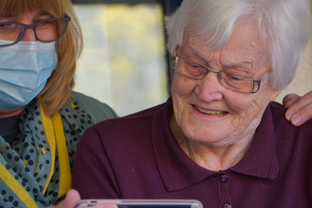 A therapist and her patient look at a phone