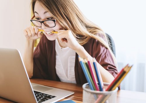 Woman stressing out with pencil in mouth